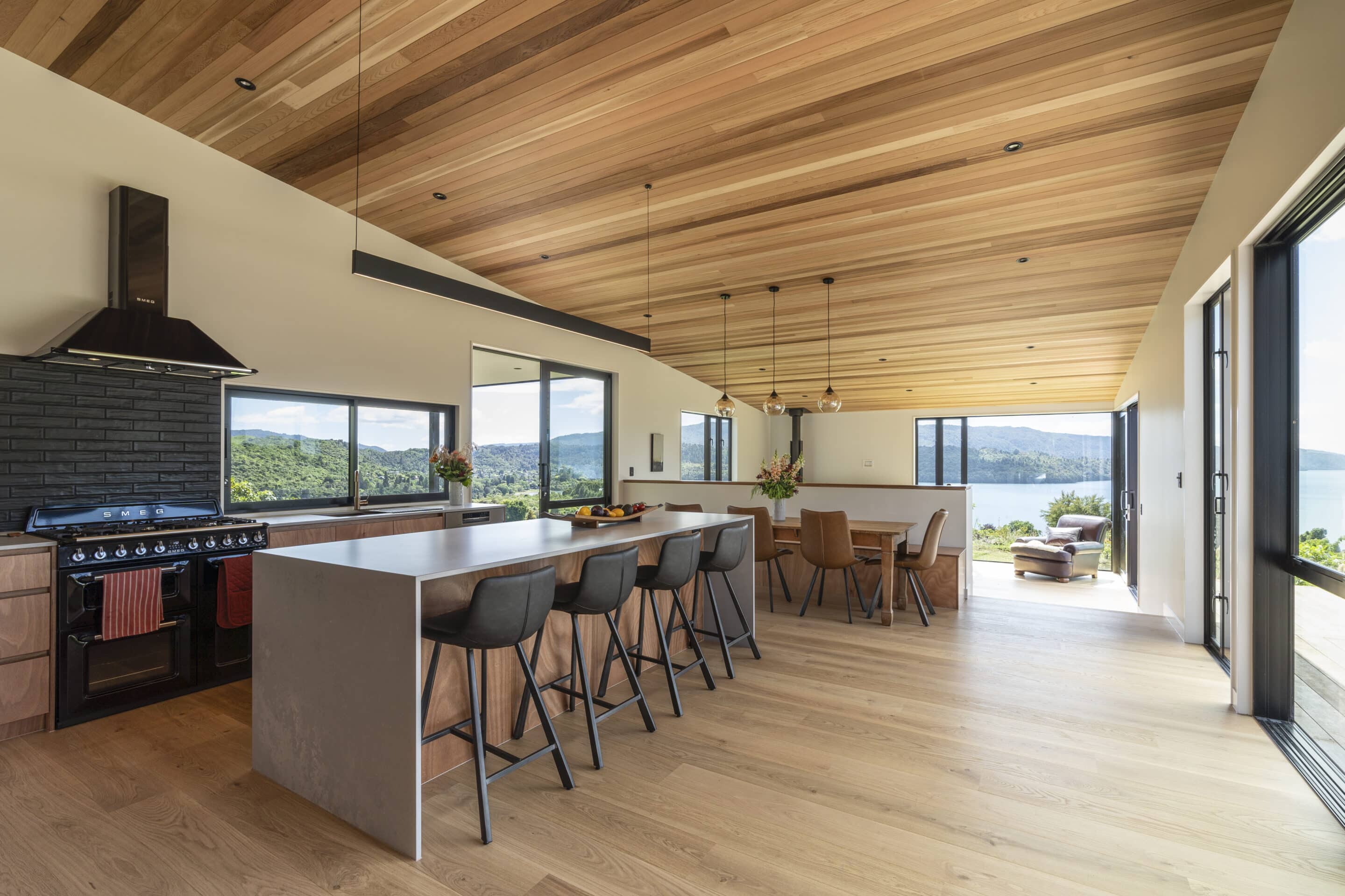 White oak hardwood flooring in open plan living dining with timber ceilings and a view